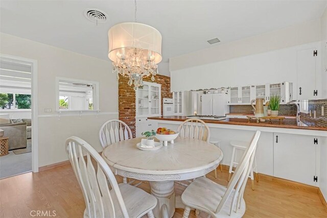 252 W 15th St, Upland, CA 91786 - dining space featuring light wood-type flooring and a chandelier
