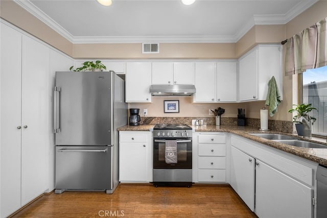 9676 Bloomfield St, Cypress, CA 90630 - kitchen featuring stainless steel appliances, under cabinet range hood, white cabinets, ornamental molding, and wood finished floors