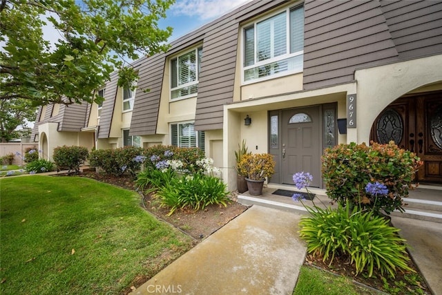 9676 Bloomfield St, Cypress, CA 90630 - doorway to property featuring stucco siding and a yard