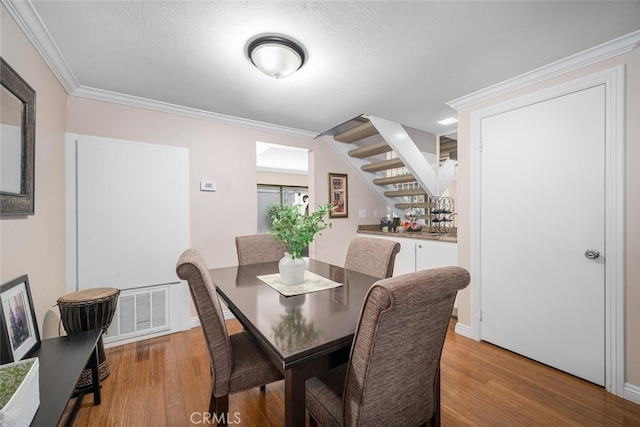 9676 Bloomfield St, Cypress, CA 90630 - dining area with wood finished floors, crown molding, stairway, and a textured ceiling