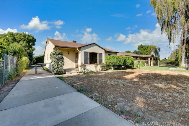 11701 Roseglen St, El Monte, CA 91732 - view of front of home with a gate, stucco siding, concrete driveway, and a chimney