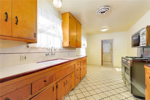 11701 Roseglen St, El Monte, CA 91732 - kitchen featuring appliances with stainless steel finishes, light flooring, decorative backsplash, tile counters, and brown cabinetry