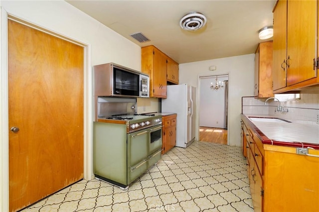 11701 Roseglen St, El Monte, CA 91732 - kitchen with stainless steel microwave, white fridge with ice dispenser, range with gas cooktop, light floors, and tasteful backsplash