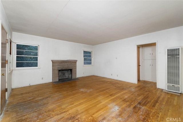 11701 Roseglen St, El Monte, CA 91732 - unfurnished living room with a heating unit, wood finished floors, and a fireplace with flush hearth