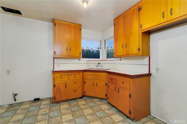 11701 Roseglen St, El Monte, CA 91732 - kitchen with tile countertops, brown cabinets, and decorative backsplash