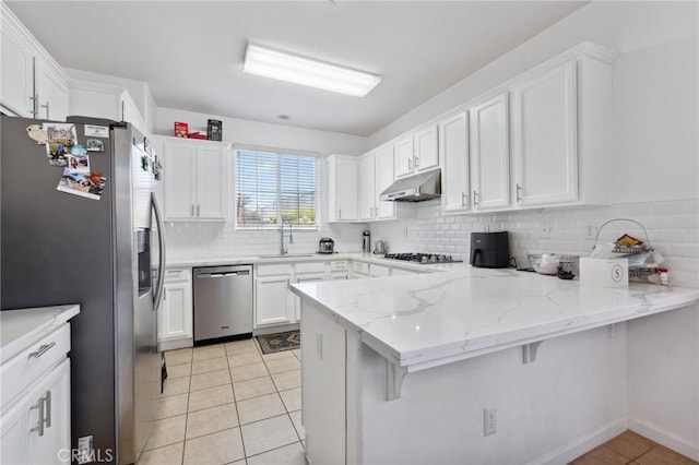 5529 N Valdez, Fresno, CA 93722 - kitchen featuring appliances with stainless steel finishes, under cabinet range hood, a peninsula, and white cabinetry