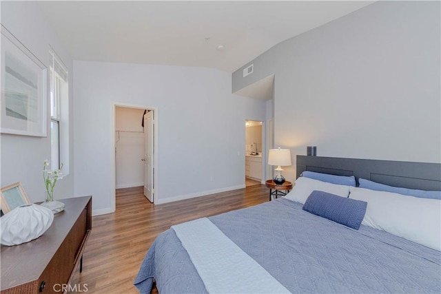 500 Tropea Aisle, Irvine, CA 92606 - bedroom featuring lofted ceiling, wood finished floors, a spacious closet, and ensuite bath