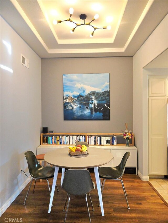 500 Tropea Aisle, Irvine, CA 92606 - dining room with a tray ceiling, a chandelier, and wood finished floors