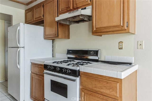 28006 S Western Ave Unit 267, San Pedro, CA 90732 - kitchen featuring under cabinet range hood, white appliances, light tile patterned flooring, tile counters, and brown cabinetry