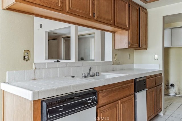 28006 S Western Ave Unit 267, San Pedro, CA 90732 - kitchen with dishwashing machine, brown cabinets, tile countertops, and light tile patterned flooring