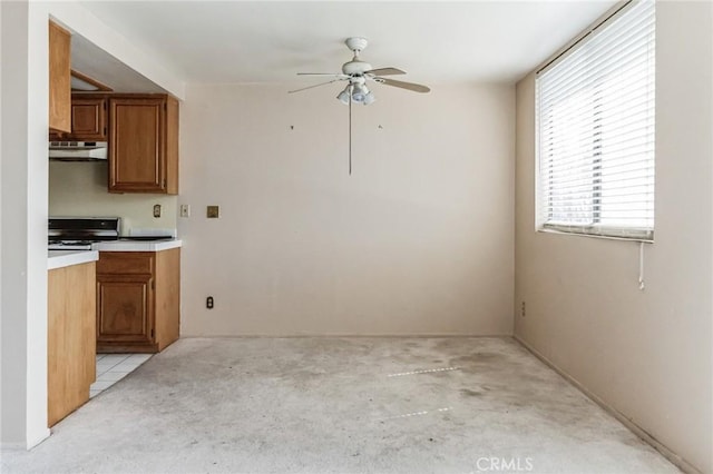 28006 S Western Ave Unit 267, San Pedro, CA 90732 - kitchen featuring stove, a ceiling fan, brown cabinets, under cabinet range hood, and light countertops