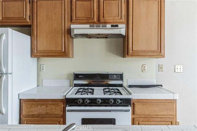28006 S Western Ave Unit 267, San Pedro, CA 90732 - kitchen featuring under cabinet range hood, white appliances, tile counters, and brown cabinets