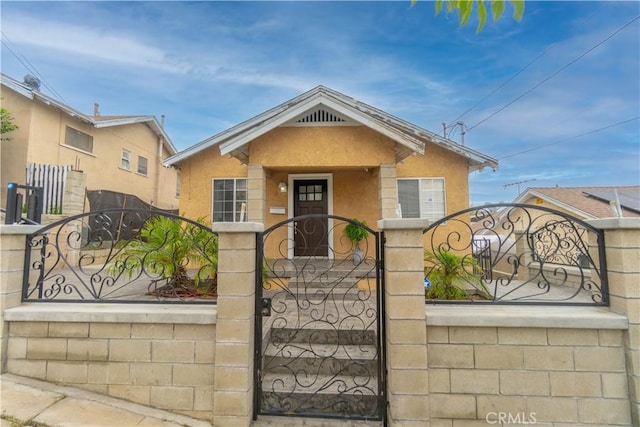 3219 E 6th St, Los Angeles, CA 90023 - bungalow-style house with a gate, a fenced front yard, and stucco siding