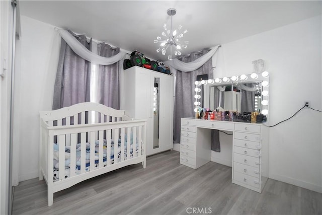 3219 E 6th St, Los Angeles, CA 90023 - bedroom with a chandelier, light wood-type flooring, and a nursery area