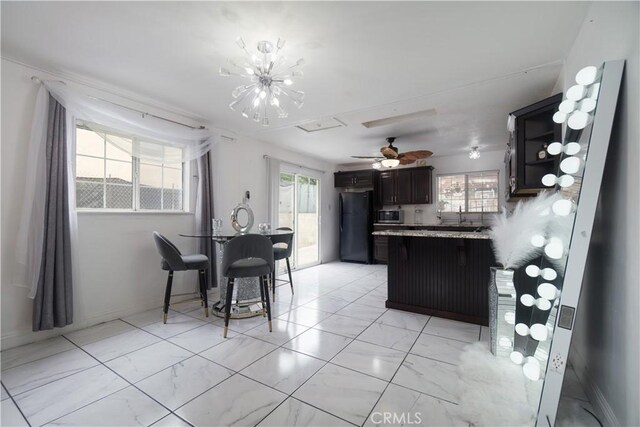 3219 E 6th St, Los Angeles, CA 90023 - kitchen featuring freestanding refrigerator, light marble finish flooring, stainless steel microwave, a peninsula, and light countertops