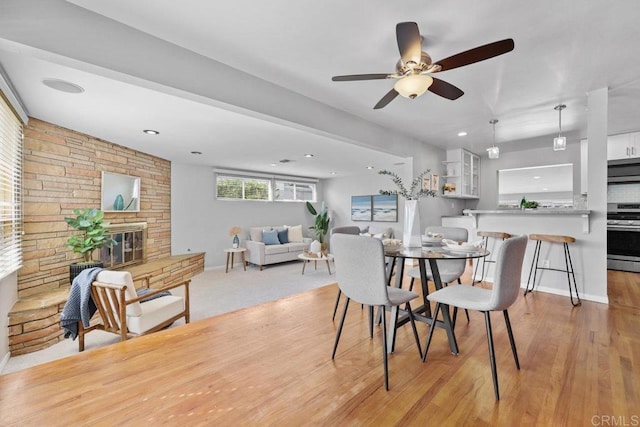 3833 Tomahawk Ln, San Diego, CA 92117 - dining space featuring a ceiling fan, a fireplace, recessed lighting, and light wood-style flooring