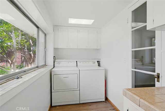 185 N Rodecker Dr, Azusa, CA 91702 - laundry room featuring washing machine and clothes dryer, a skylight, cabinet space, and wood finished floors