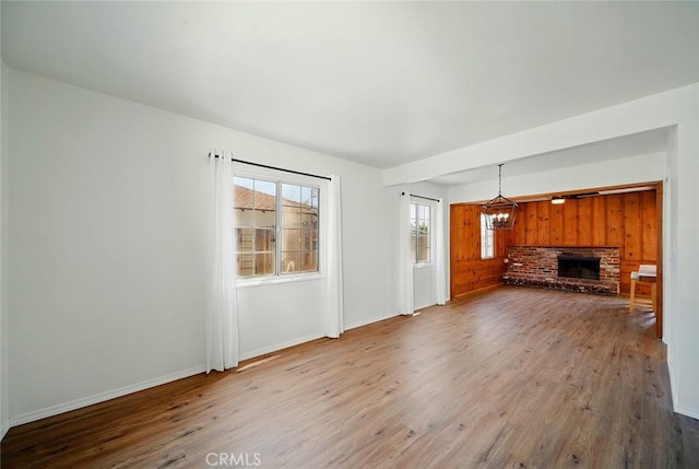 185 N Rodecker Dr, Azusa, CA 91702 - unfurnished living room with wood finished floors, a chandelier, and a brick fireplace