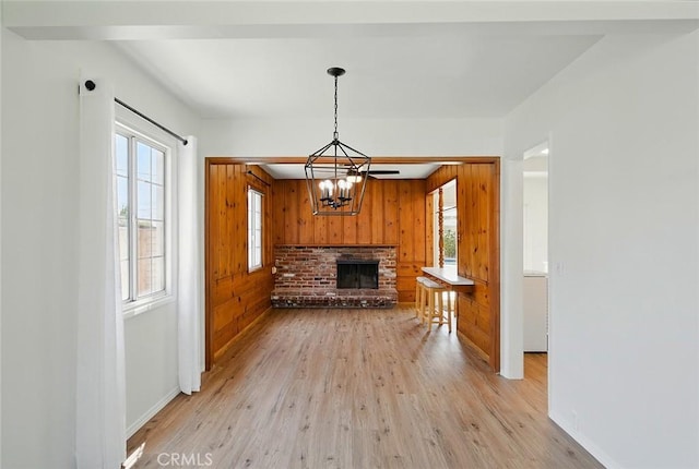 185 N Rodecker Dr, Azusa, CA 91702 - unfurnished living room featuring wood walls, light wood-style floors, a chandelier, and a fireplace