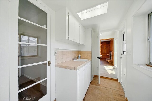 185 N Rodecker Dr, Azusa, CA 91702 - laundry area with a skylight, light wood-style floors, and plenty of natural light