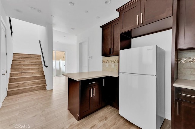 7419 N Mia Ln, Van Nuys, CA 91405 - kitchen with freestanding refrigerator, a peninsula, tasteful backsplash, and dark brown cabinets