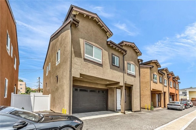 7419 N Mia Ln, Van Nuys, CA 91405 - view of front of home with stucco siding, a garage, and asphalt driveway