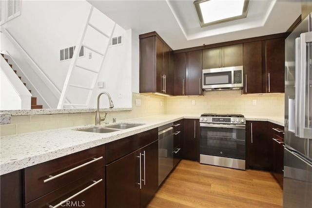 35 Linden Ave Unit 504, Long Beach, CA 90802 - kitchen featuring stainless steel appliances, tasteful backsplash, light wood-type flooring, and light stone counters