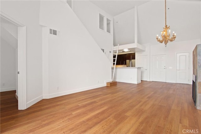 35 Linden Ave Unit 504, Long Beach, CA 90802 - unfurnished living room with high vaulted ceiling, a chandelier, and light wood-type flooring