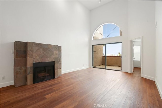 35 Linden Ave Unit 504, Long Beach, CA 90802 - unfurnished living room featuring a towering ceiling, wood finished floors, and a fireplace