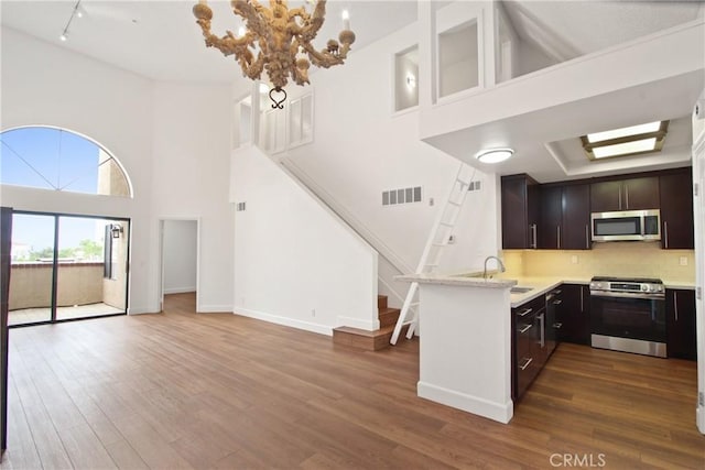 35 Linden Ave Unit 504, Long Beach, CA 90802 - kitchen featuring appliances with stainless steel finishes, light countertops, a high ceiling, open floor plan, and dark wood-style flooring