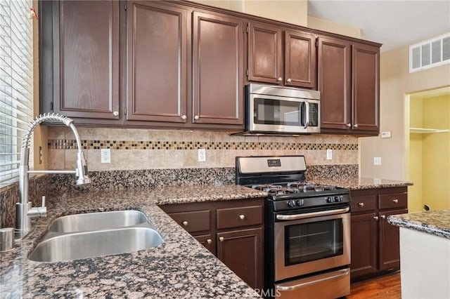 12910 Jersey St, Eastvale, CA 92880 - kitchen with appliances with stainless steel finishes, decorative backsplash, dark stone countertops, and dark brown cabinetry