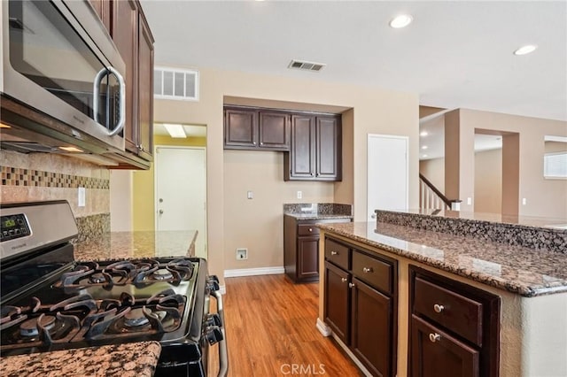 12910 Jersey St, Eastvale, CA 92880 - kitchen featuring stainless steel appliances, light wood finished floors, stone countertops, decorative backsplash, and dark brown cabinetry