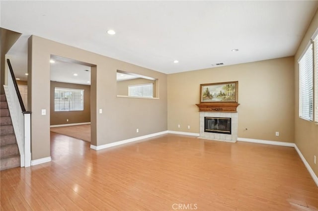 12910 Jersey St, Eastvale, CA 92880 - unfurnished living room with a tile fireplace, light wood-type flooring, stairs, healthy amount of natural light, and recessed lighting