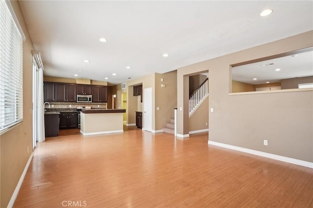 12910 Jersey St, Eastvale, CA 92880 - unfurnished living room with light wood-style floors, recessed lighting, and stairs