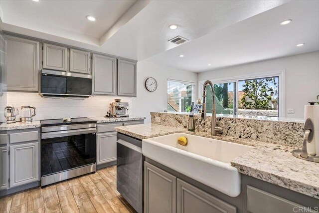 17915 Caminito Pinero Unit 264, San Diego, CA 92128 - kitchen featuring stainless steel appliances, gray cabinets, light wood-style flooring, tasteful backsplash, and recessed lighting