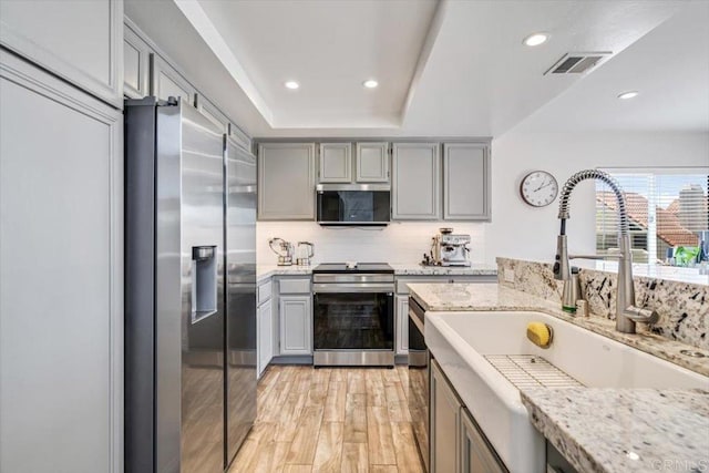 17915 Caminito Pinero Unit 264, San Diego, CA 92128 - kitchen featuring stainless steel appliances, gray cabinets, tasteful backsplash, recessed lighting, and light wood-style flooring