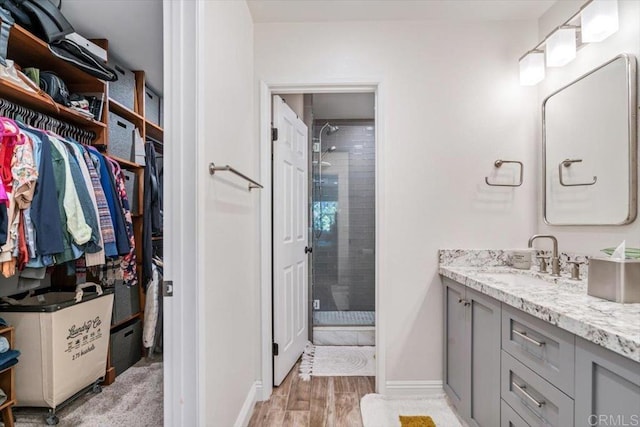 17915 Caminito Pinero Unit 264, San Diego, CA 92128 - bathroom with vanity, a stall shower, a spacious closet, and wood finished floors