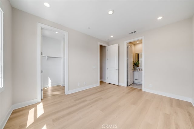 211 Wild Flower, Lake Forest, CA 92630 - unfurnished bedroom with light wood-style flooring, a spacious closet, recessed lighting, a closet, and ensuite bath