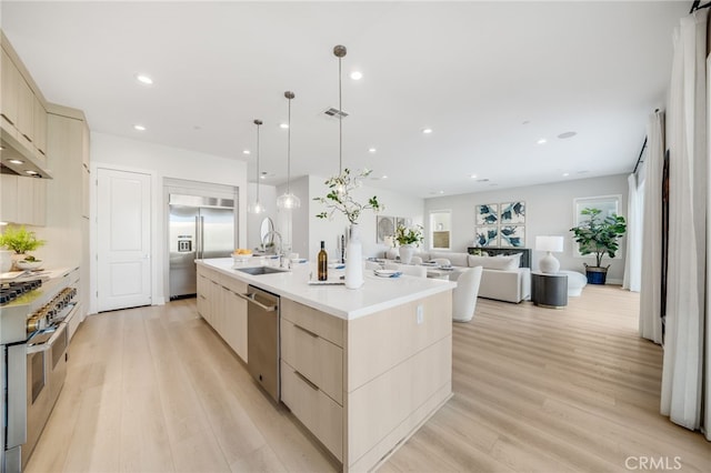 211 Wild Flower, Lake Forest, CA 92630 - kitchen featuring premium appliances, modern cabinets, light wood-style flooring, a large island, and light brown cabinetry