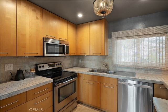 837 N W Knoll Dr Unit 307, West Hollywood, CA 90069 - kitchen with stainless steel appliances, decorative backsplash, tile counters, and light tile patterned flooring