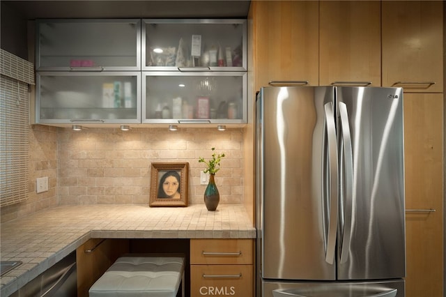837 N W Knoll Dr Unit 307, West Hollywood, CA 90069 - kitchen featuring freestanding refrigerator, backsplash, light countertops, and glass insert cabinets