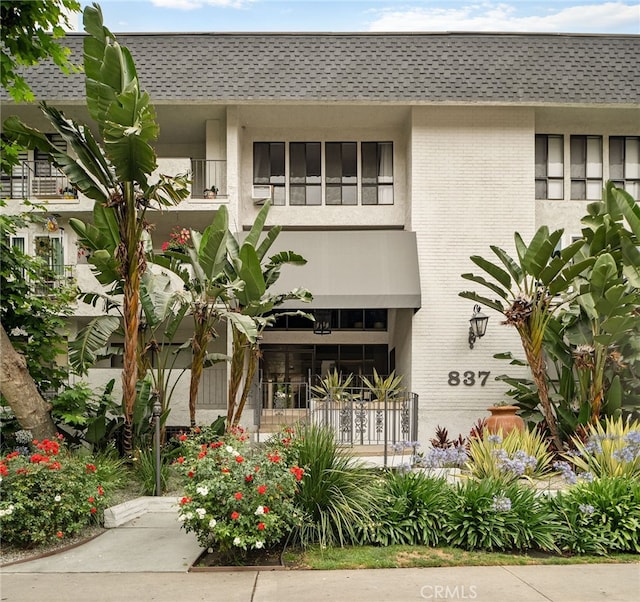 837 N W Knoll Dr Unit 307, West Hollywood, CA 90069 - view of front of house with roof with shingles, brick siding, and mansard roof