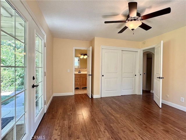 2817 San Verbena Way, Chico, CA 95973 - unfurnished bedroom with dark wood-type flooring, arched walkways, access to exterior, french doors, and a closet