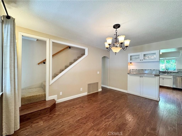 2817 San Verbena Way, Chico, CA 95973 - kitchen featuring stainless steel counters, arched walkways, dark wood finished floors, white cabinetry, and a chandelier