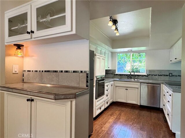 2817 San Verbena Way, Chico, CA 95973 - kitchen with stainless steel appliances, backsplash, dark wood-style floors, white cabinetry, and glass insert cabinets