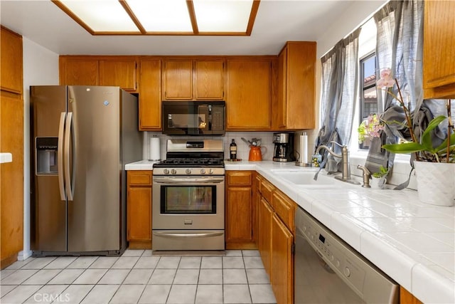854 N Harbor Blvd, La Habra, CA 90631 - kitchen featuring appliances with stainless steel finishes, tile countertops, brown cabinets, and decorative backsplash