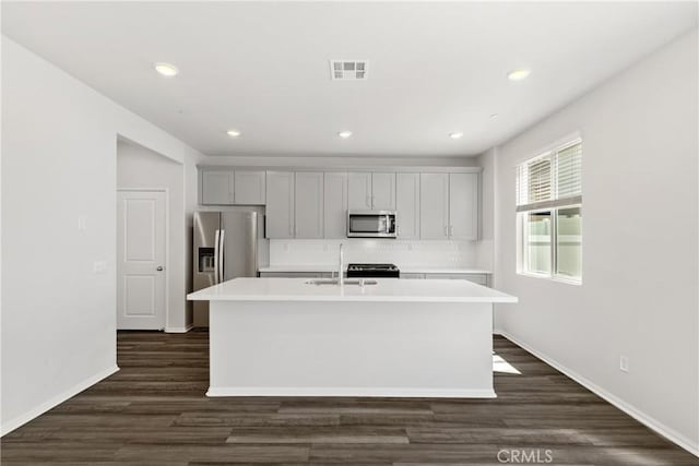 36390 W Flare, Winchester, CA 92569 - kitchen with appliances with stainless steel finishes, a kitchen island with sink, light countertops, decorative backsplash, and recessed lighting