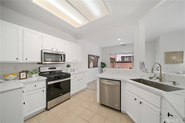 14840 Dove Tree Ct, Tustin, CA 92780 - kitchen featuring appliances with stainless steel finishes, white cabinetry, light stone countertops, light tile patterned floors, and recessed lighting