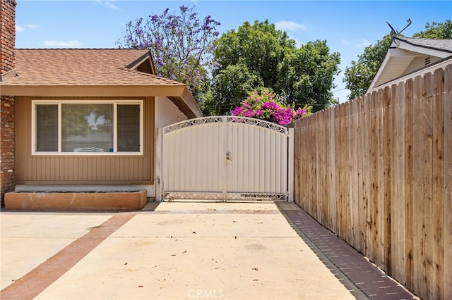 4215 Sherman Dr, Riverside, CA 92503 - view of home's exterior with roof with shingles, a gate, a patio, and a chimney