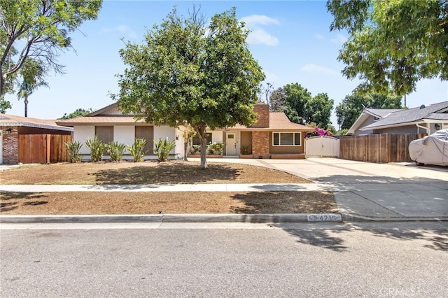 4215 Sherman Dr, Riverside, CA 92503 - view of front facade featuring concrete driveway, a chimney, and a gate